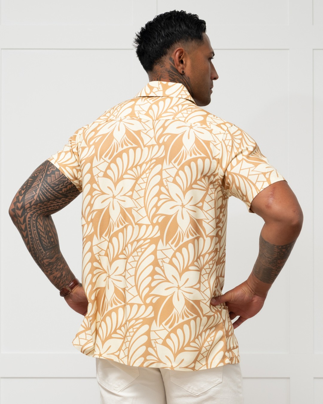 Man wearing a beige and white floral patterned shirt against a white background