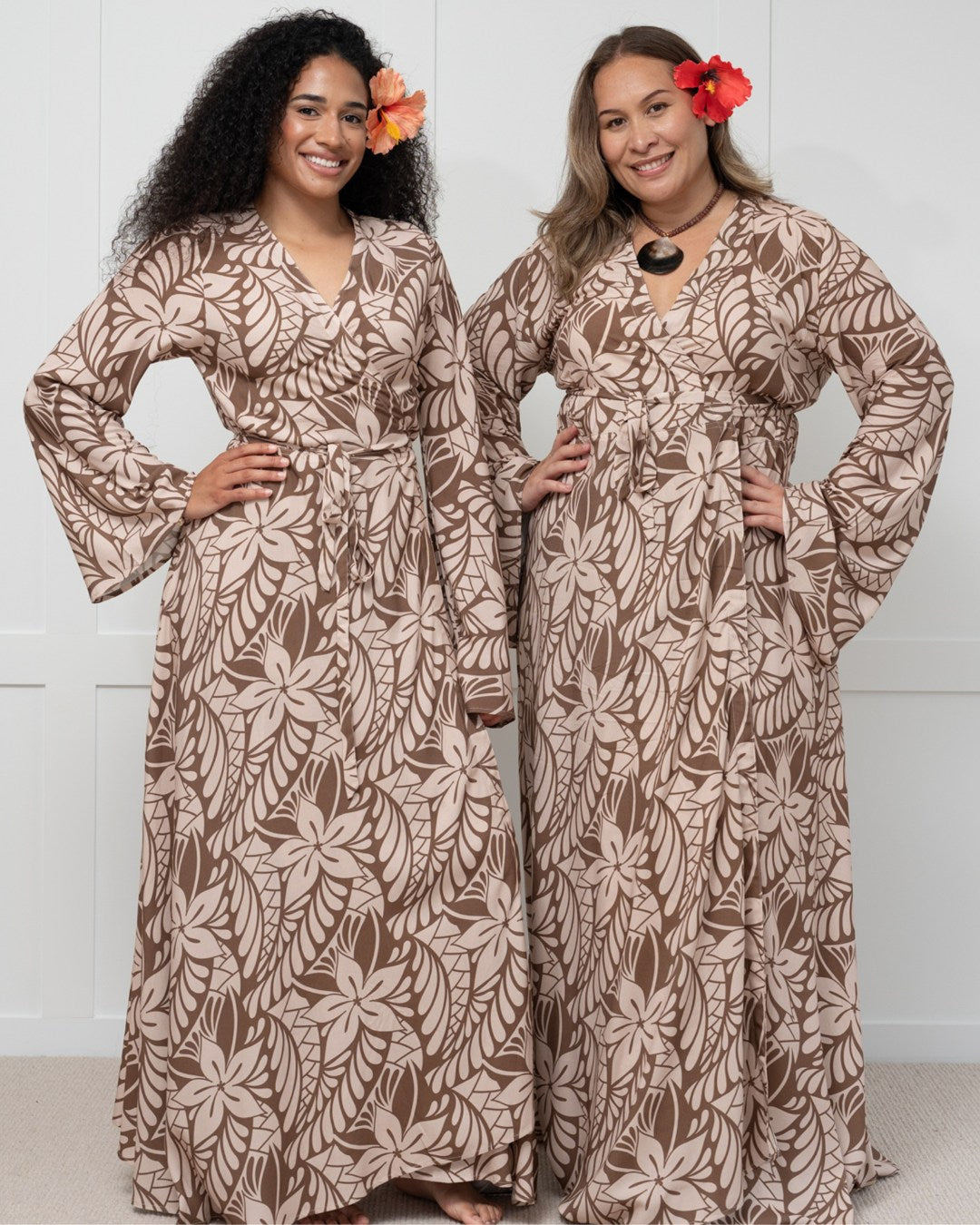 Woman wearing a long brown floral island dress against a white background
