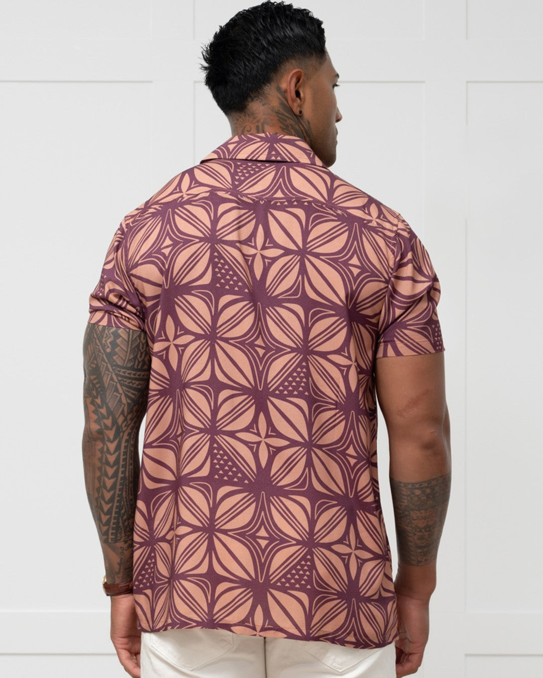 Man wearing a patterned island shirt with a white background